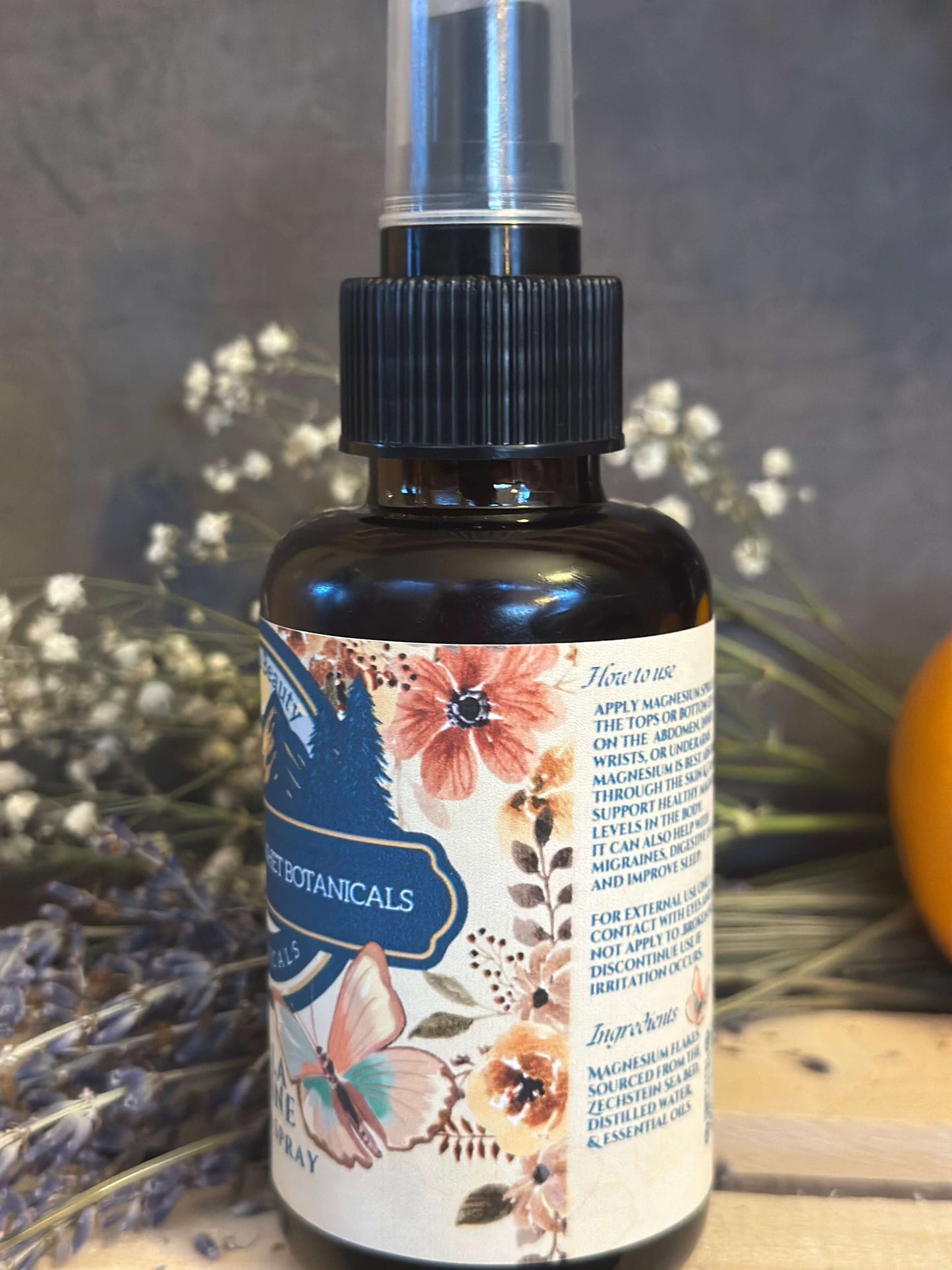 Amber glass spray bottle of magnesium oil on dried flower background