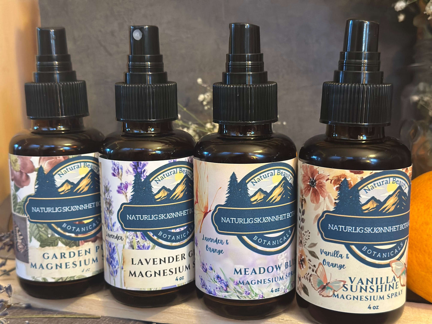Lineup of magnesium spray bottles in four natural scent options with designer labels