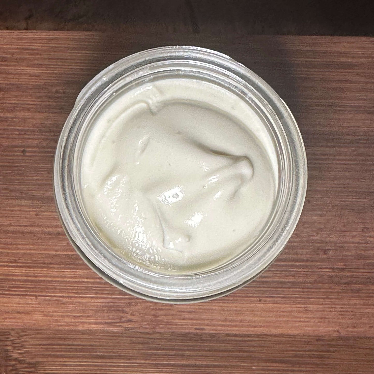 Jar of Summer Shield botanical body butter with creamy texture for sun-exposed skin
