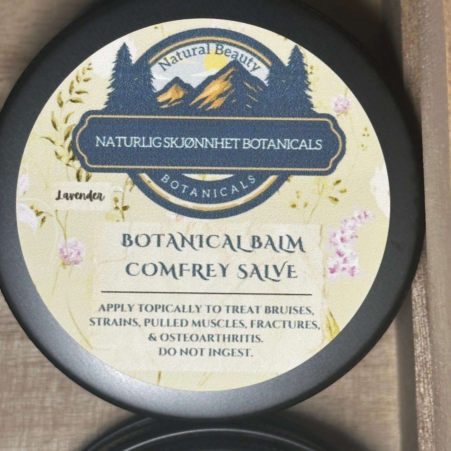 Botanical Balm Comfrey Salve jar with lavender label, natural skincare for bruises, strains, and joint support.