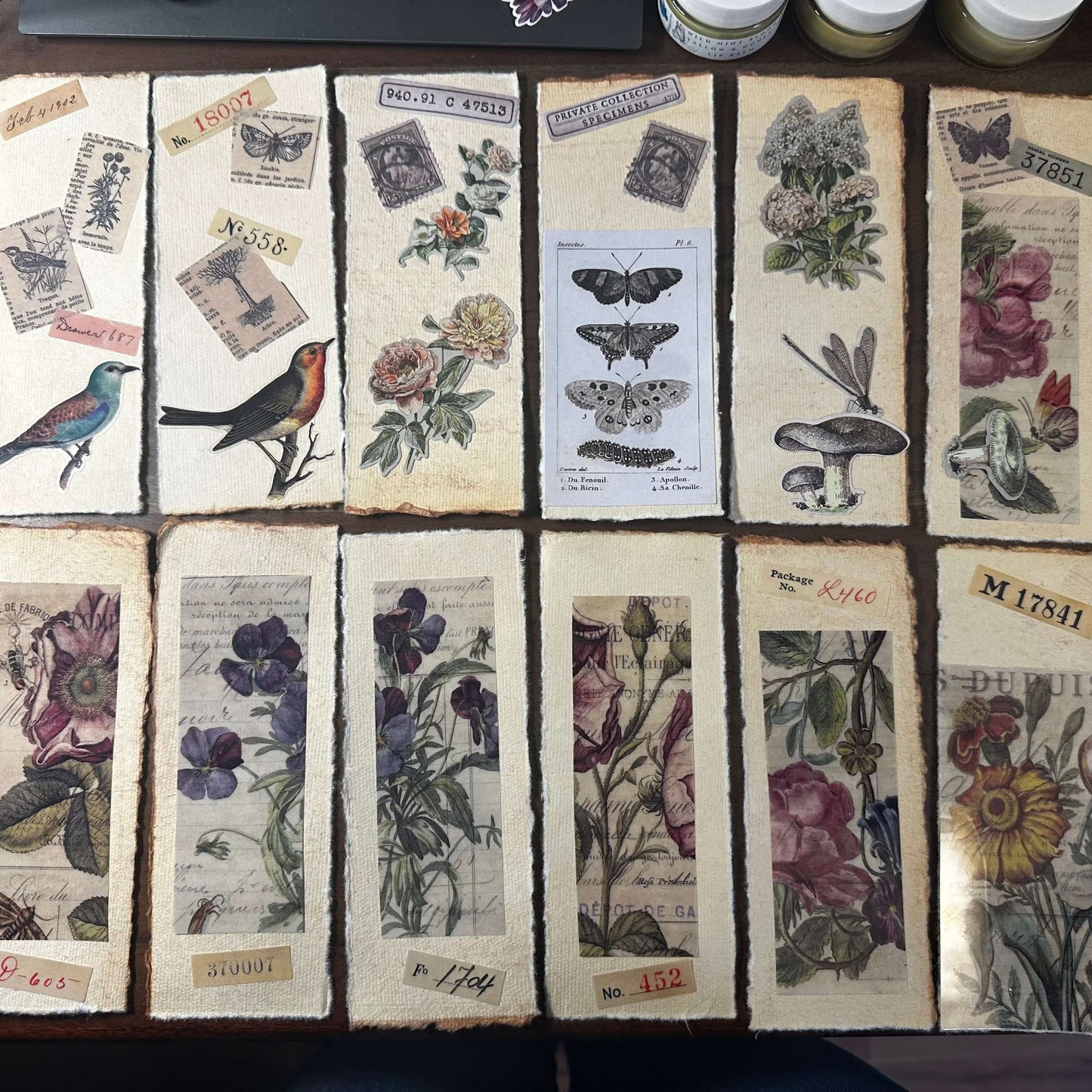 Handmade botanical bookmarks featuring pressed flowers, birds, and vintage illustrations on cotton paper.
