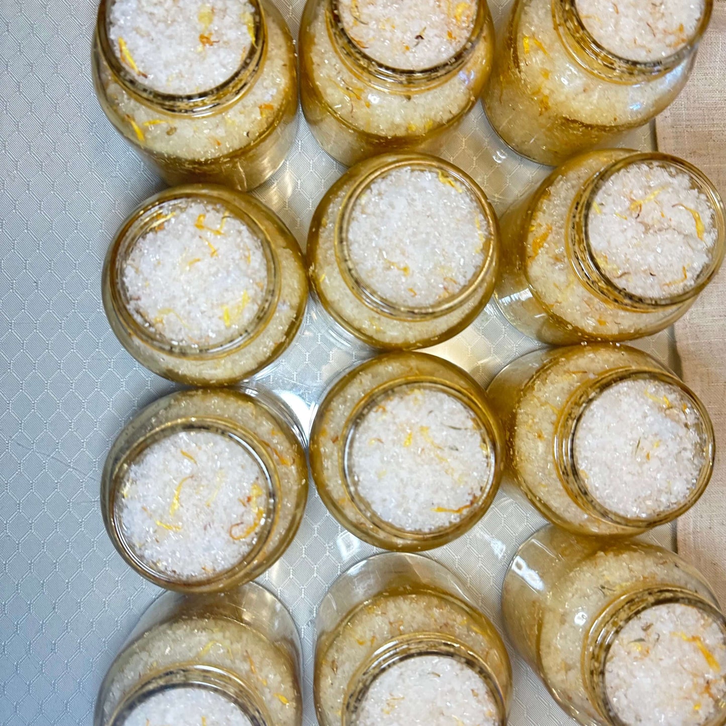 Jars of all-natural botanical body scrub showcasing Epsom and sea salt, perfect for smooth and glowing skin.