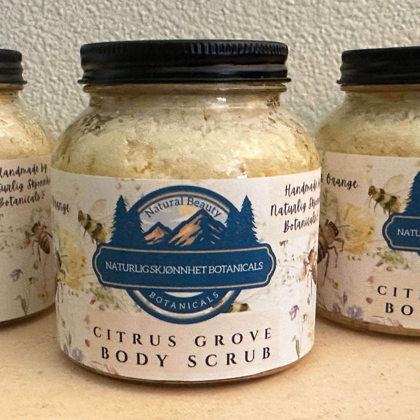 Citrus Grove Body Scrub by Naturlig Skjonnhet Botanicals in a glass jar, showcasing a refreshing, handmade natural scrub.